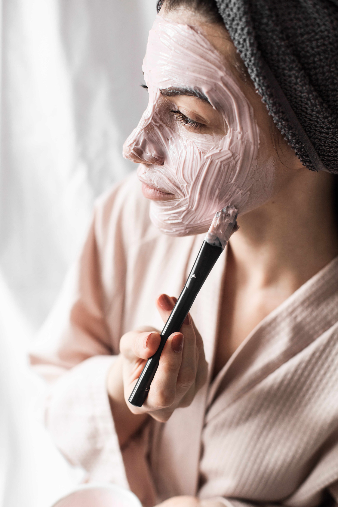Woman in Bathrobe Applying Face Mask with a Brush